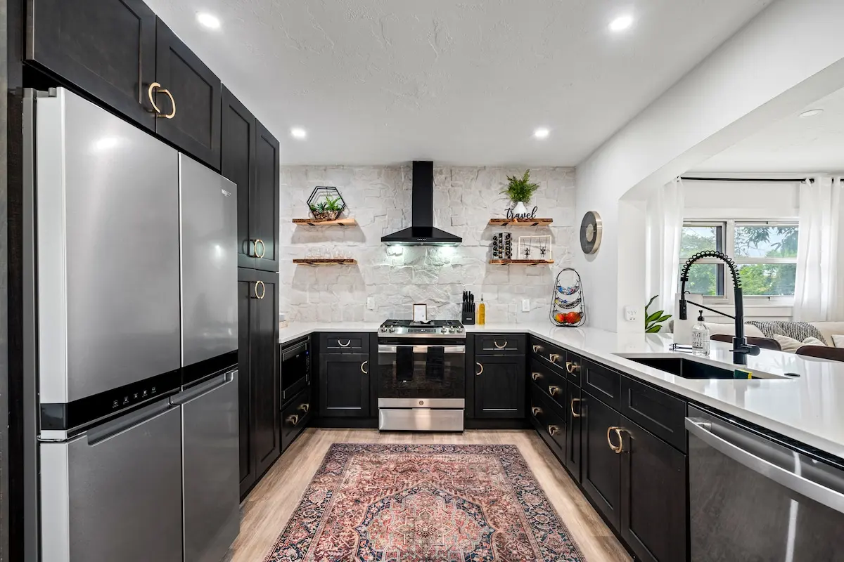 Our glam-meets-modern kitchen is fully stocked and ready to host your inner chef — complete with sleek black cabinets, gold accents, and a cozy coffee corner.